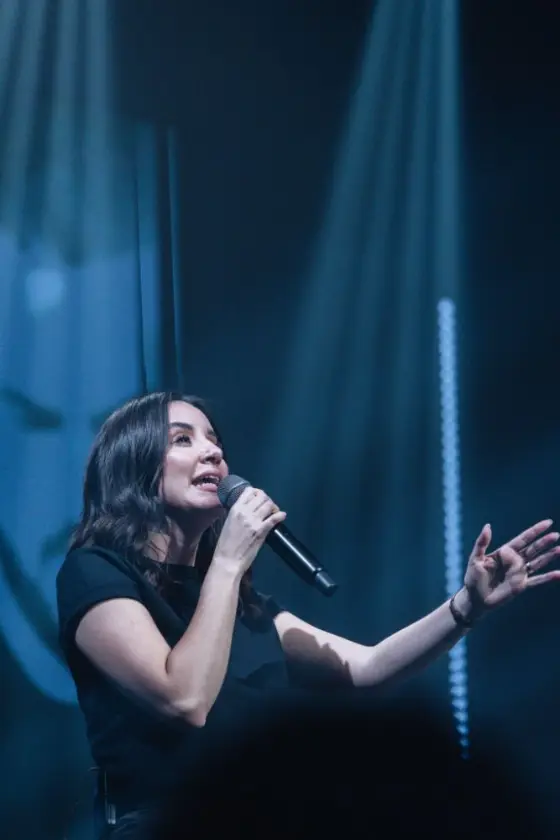 Cantora da Worsheep com a mão estendida durante a ministração